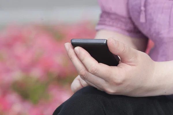 Kvinna med smartphone i hand — Stockfoto