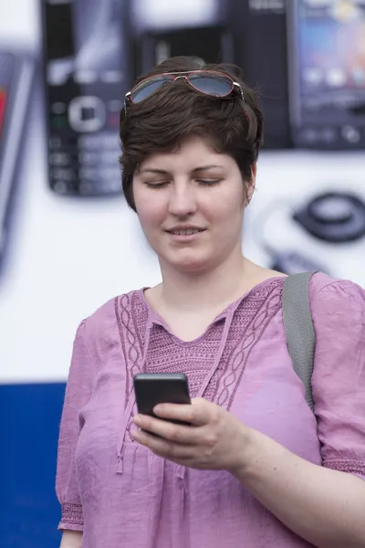 Vrouw met mobiele telefoon wandelen — Stockfoto