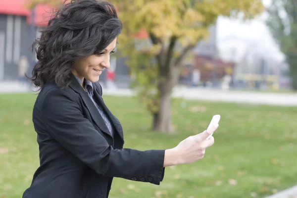 Vrouw met mobiele telefoon wandelen — Stockfoto