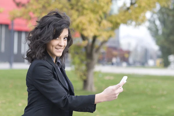 Vrouw met mobiele telefoon wandelen — Stockfoto