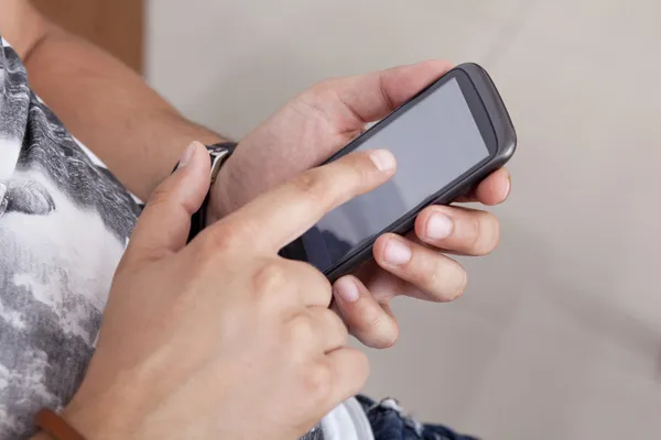 Adulto joven usando un teléfono inteligente — Foto de Stock