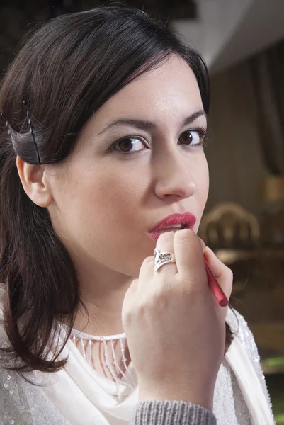 Mujer joven teniendo maquillaje de ojos aplicado —  Fotos de Stock