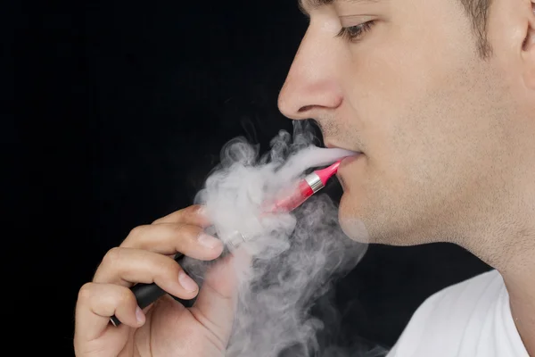 Young man smoking E-cigarette — Stock Photo, Image