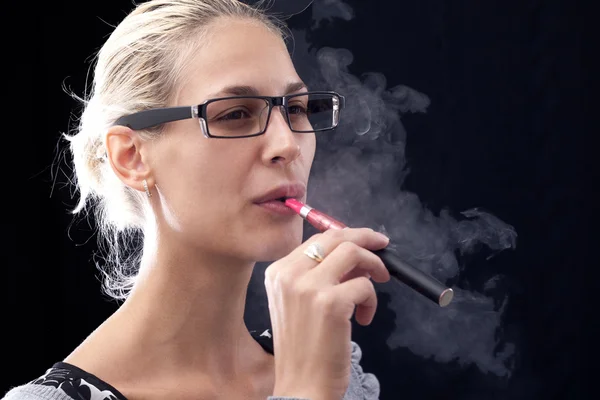 Junge Frau raucht E-Zigarette — Stockfoto