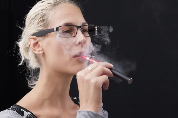 Jovem mulher fumando cigarro eletrônico — Fotografia de Stock