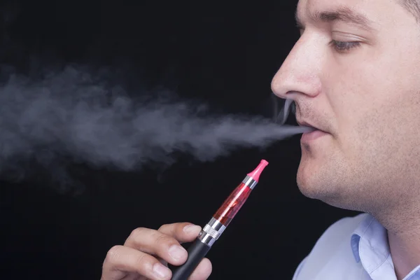 Young man smoking E-cigarette — Stock Photo, Image