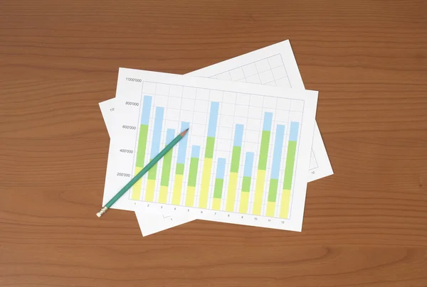 Werkplek met pen en papier met grafieken — Stockfoto
