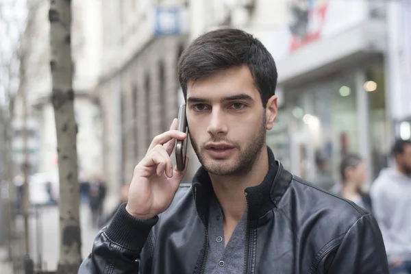 Молодий чоловік розмовляє з мобільним телефоном — стокове фото