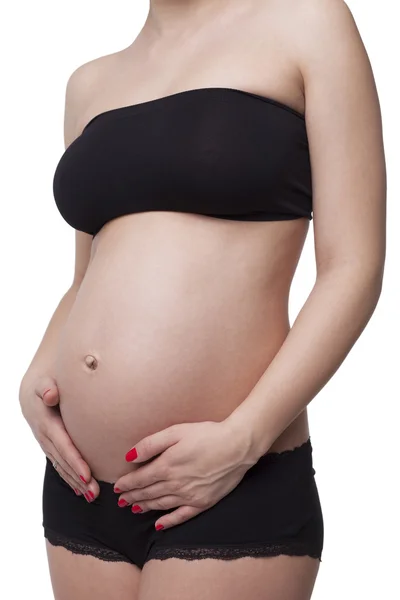 Woman holding her pregnant belly. White background. — Stock Photo, Image