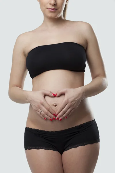 Mulher segurando sua barriga grávida. Fundo branco . — Fotografia de Stock