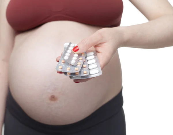 Mujer embarazada sosteniendo pastillas — Foto de Stock