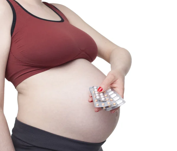 Pregnant woman holding pills — Stockfoto