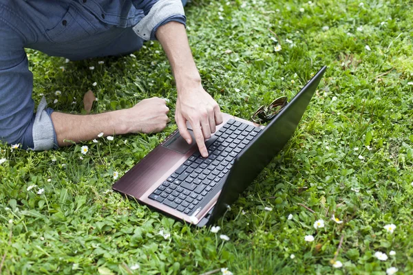 Mann benutzt Laptop im Park — Stockfoto