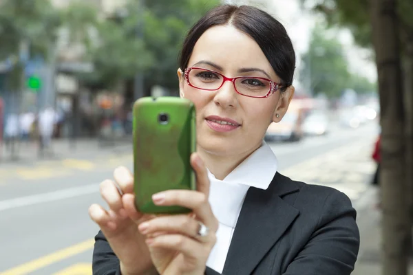 Affärskvinna som tar en bild med mobiltelefon — Stockfoto