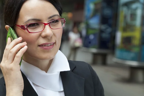 Mujer de negocios sonriente hablando vía móvil —  Fotos de Stock