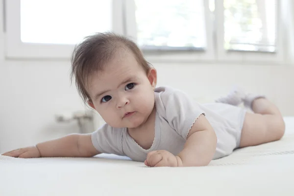 Baby flicka på hennes mage — Stockfoto