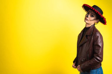 Kalavera Katrina, vücudunun, yüzünün çeşitli duygusal hareketlerini, sarı arka planda Sambrero 'nun yanlamasına durduğunu, düz, yanlamasına, yazı için yere baktığını gösteriyor. Ölüm günü. Cadılar Bayramı