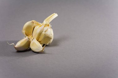 Ayrı karanfilli gri arka planda sarımsak kafa. Doğal ürün.