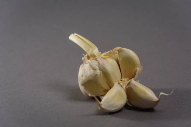 Ayrı karanfilli gri arka planda sarımsak kafa. Doğal ürün.