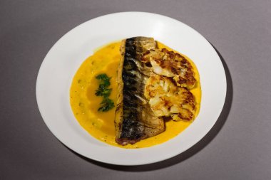 Fırında pişirmeden önce sebzeli, patatesli, havuçlu taze moraine uskumrusu, metal bir şekilde. Sebzeli balık. Gri arkaplan, üst manzara. Ev yemekleri.