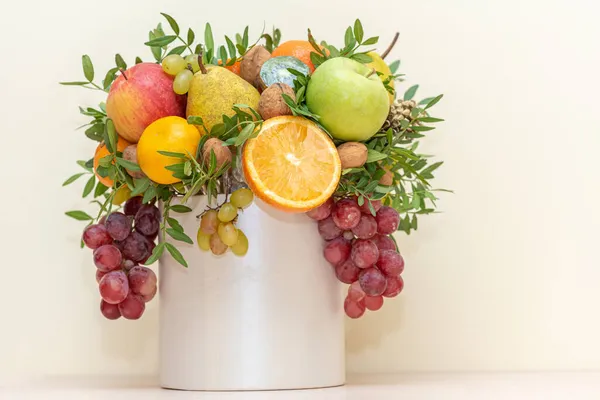 Bouquet of fruits and flowers. Apples, pears, oranges, tangerines, grapes, eucalyptus nuts and cloves.