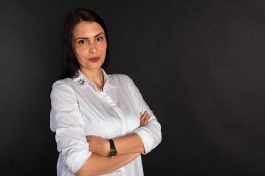 Portre, gülümseyen, çekici, orta yaşlı bir kızın karanlık bir arka planda çekilmiş bir fotoğrafı.