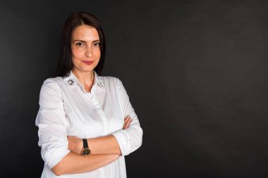 Portre, gülümseyen, çekici, orta yaşlı bir kızın karanlık bir arka planda çekilmiş bir fotoğrafı.