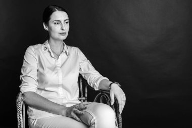 Siyah-beyaz bir portre, stüdyo fotoğrafı, güzel, duygusal oldukça çekici orta yaşlı bir kız koyu bir arka planda.