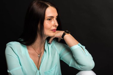 Portre, gülümseyen, çekici, orta yaşlı, dalgalı saçlı, esmer bir kızın stüdyo fotoğrafı..