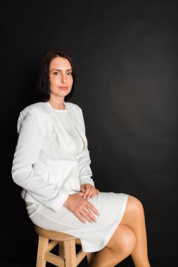 Portre, gülümseyen, çekici, orta yaşlı bir kızın karanlık bir arka planda çekilmiş bir fotoğrafı.