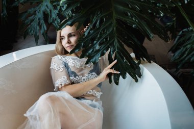 Açık havada tropik çiçeklerle, organik cilt bakımıyla lüks bir spa otelinde, yaşam tarzı fotoğrafıyla rahatlayan bir kadın..