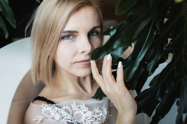 Açık havada tropik çiçeklerle, organik cilt bakımıyla lüks bir spa otelinde, yaşam tarzı fotoğrafıyla rahatlayan bir kadın..