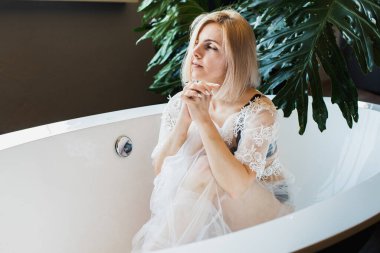 Açık havada tropik çiçeklerle, organik cilt bakımıyla lüks bir spa otelinde, yaşam tarzı fotoğrafıyla rahatlayan bir kadın..