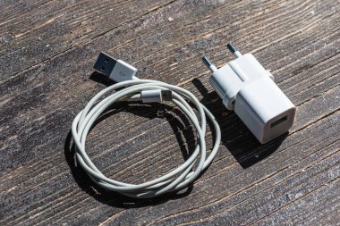 Ahşap arka planda kablo telefon şarj cihazları