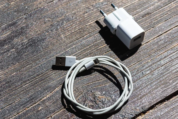 Ahşap arka planda kablo telefon şarj cihazları