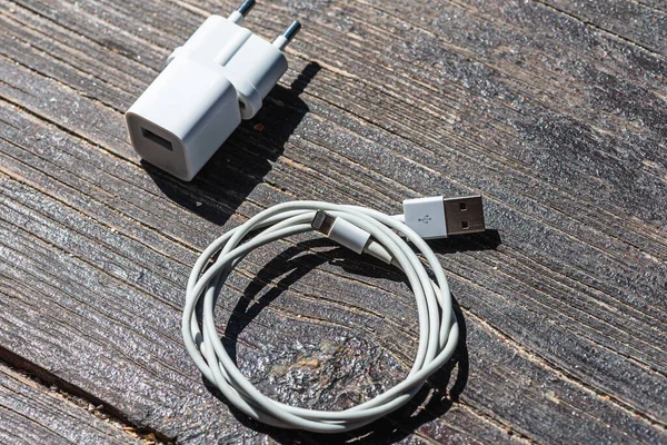 Ahşap arka planda kablo telefon şarj cihazları