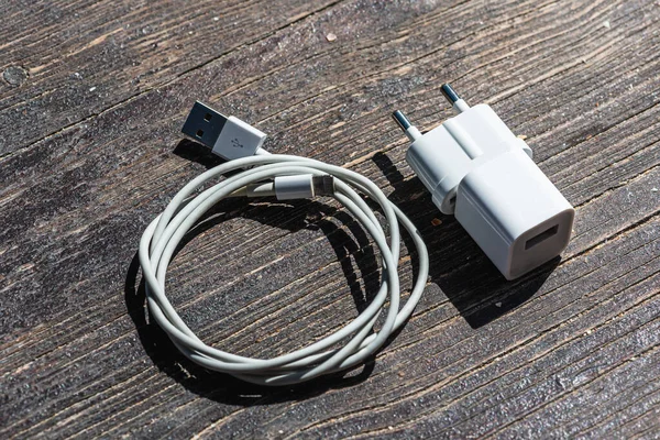Ahşap arka planda kablo telefon şarj cihazları