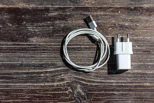 Ahşap arka planda kablo telefon şarj cihazları