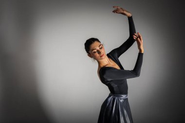 Genç, güzel balerin arka planda uzun bir elbiseyle dans etmek yazıtlara uygun bir yer. Sanat, hareket, ilham konsepti. Sivri ayakkabılı ve elbiseli klasik balerin. Seçici odak 