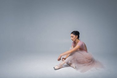 Arka planda oturan yorgun balerin.