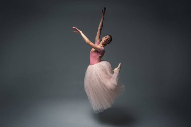 Havada dans eden balerin. Genç, güzel, narin, güzel balerin, uzun soluk pembe bir elbiseyle dans ediyor. Bale, dans, dansçı. Alçak tuş