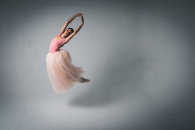 Havada dans eden balerin. Genç, güzel, narin, güzel balerin, uzun soluk pembe bir elbiseyle dans ediyor. Bale, dans, dansçı. Alçak tuş