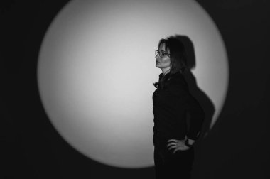 Genç, gülümseyen, pozitif, duygusal, güzel bir kız sırtı masaya dönmüş çalışıyor ve orta boy bir sigara gösteriyor, işten boş zamanlarının keyfini çıkarıyor, uzaktan çalışıyor, işten yorgun.