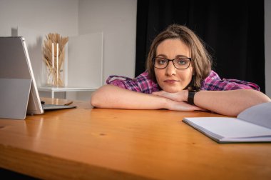 Genç, gülümseyen, olumlu, duygusal, güzel bir kız, çalışıyor, işten izin alıp bilgisayar başında çalışıyor, uzaktan çalışıyor, çalışmaktan yorulmuş.