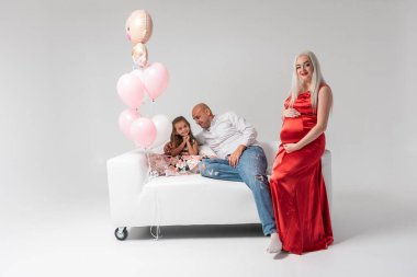 Hafif bir geçmişi olan güzel hamile bir kadın, neşeli, kutlayan ve şaşırtan. Aile ve bebek doğumu kavramı.