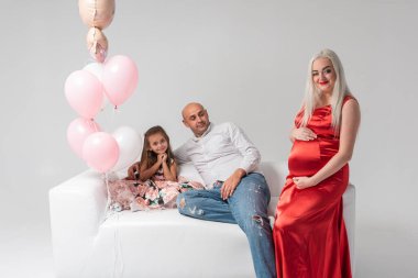 Hafif bir geçmişi olan güzel hamile bir kadın, neşeli, kutlayan ve şaşırtan. Aile ve bebek doğumu kavramı.