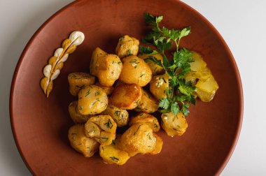 Kahverengi kil tabakta bir köylünün üzerinde kızarmış patates, ev, restoran mutfağı, beyaz arka planda izole edilmiş yemekler.
