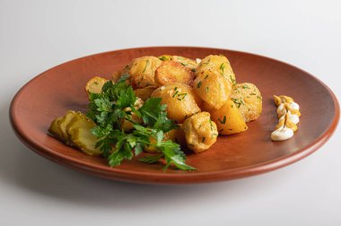 Kahverengi kil tabakta bir köylünün üzerinde kızarmış patates, ev, restoran mutfağı, beyaz arka planda izole edilmiş yemekler.