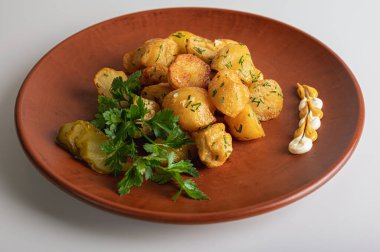 Kahverengi kil tabakta bir köylünün üzerinde kızarmış patates, ev, restoran mutfağı, beyaz arka planda izole edilmiş yemekler.