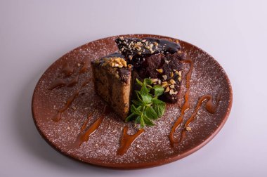 Fındıklı krep çikolatalı pasta, beyaz arka planda izole edilmiş kahverengi kil tabakta ballı kek. Yüksek kalite fotoğraf